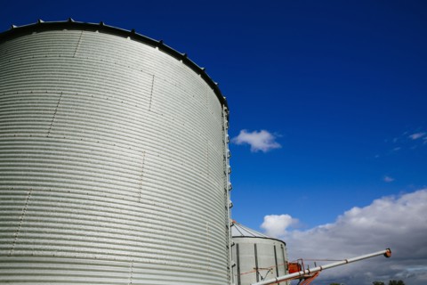 Low angle view of silos under blue sky