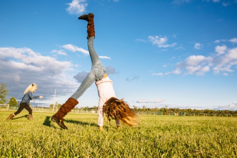 Caucasian girls playing in rural field