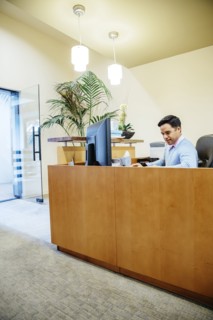 Mixed race secretary working in office lobby