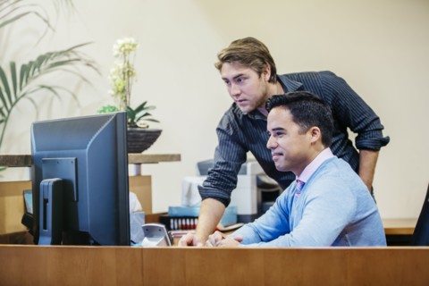 Businessmen working at computer in office lobby