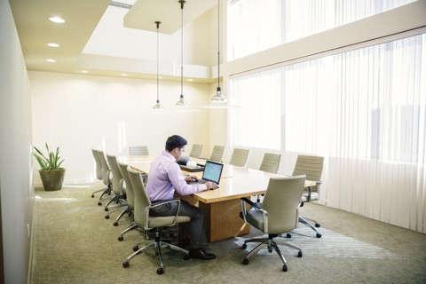 Mixed race businessman working on laptop in conference room