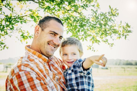 Father and son pointing on farm