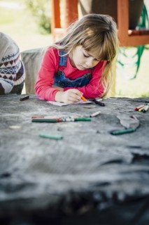 Caucasian girl coloring outdoors