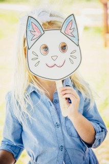 Caucasian girl holding cat mask