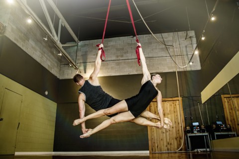 Caucasian acrobats hanging from ropes in studio