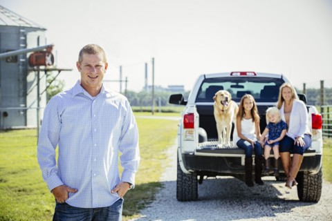 Caucasian man standing near family in truck bed
