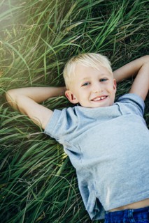 Caucasian boy laying in tall grass