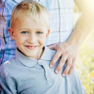 Caucasian boy smiling with father outdoors