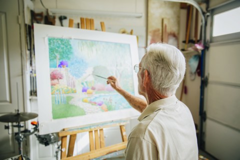 Caucasian artist painting in garage
