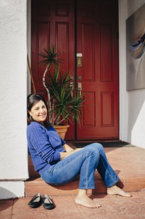 Barefoot woman sitting on front stoop