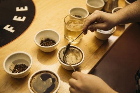 Caucasian barista tasting coffee in coffee shop