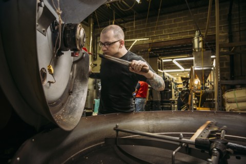 Caucasian roaster working on coffee in warehouse