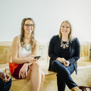 Businesswomen holding cell phones in office lobby