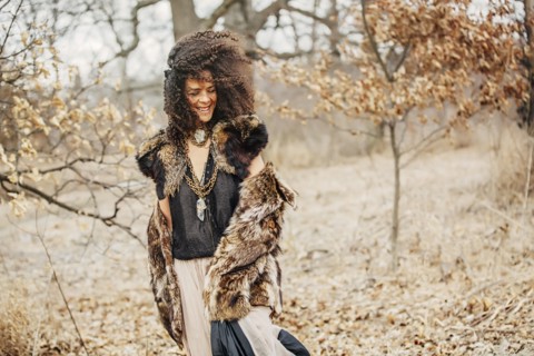 Mixed race woman wearing stylish clothes in field