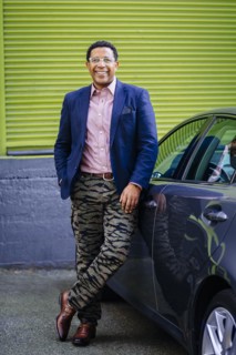 Stylish Mixed race businessman leaning on car