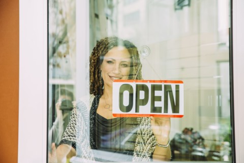 Mixed race store owner opening door
