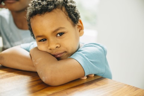Close up of boy leaning on table