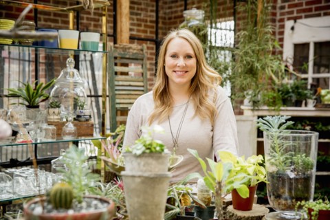 Caucasian employee smiling in plant nursery