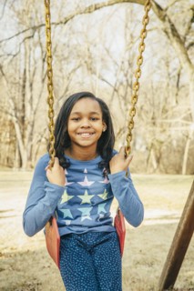 Black girl sitting on swing