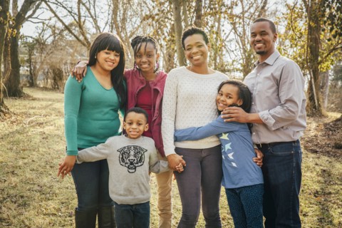 Black family smiling outdoors