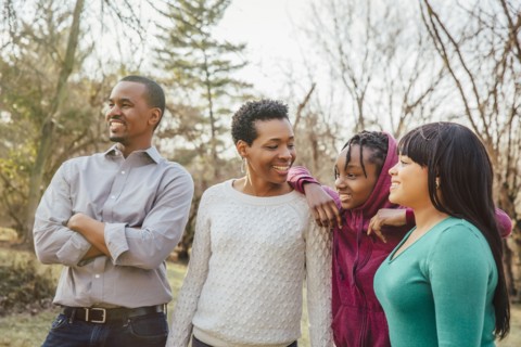 Black family smiling outdoors
