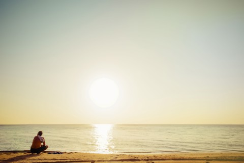 Mixed race man sitting on beach
