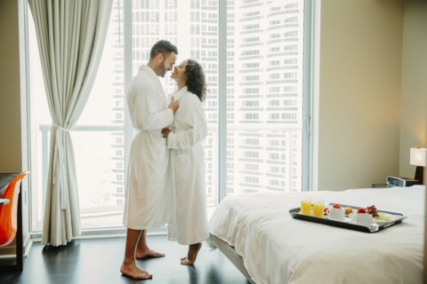 Couple hugging in bathrobes in hotel room