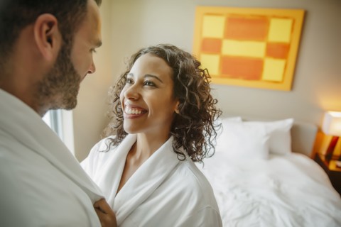 Couple hugging in bathrobes in hotel room
