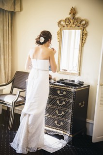 Caucasian bride applying makeup in mirror