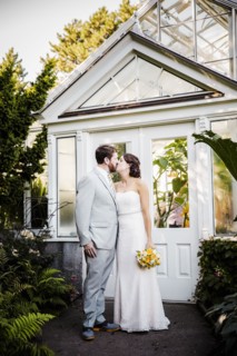 Caucasian bride and groom kissing in garden