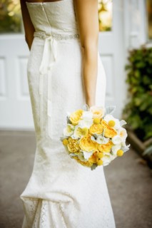 Caucasian bride holding bouquet in garden