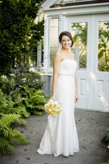 Caucasian bride holding bouquet in garden