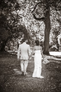 Caucasian bride and groom walking on dirt path