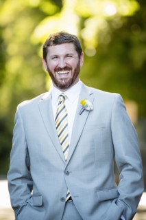 Caucasian groom laughing in garden