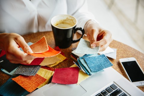 Mixed race designer examining fabric swatches