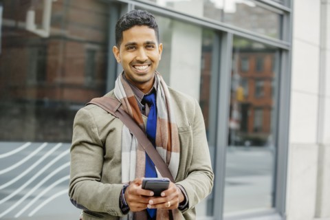 Indian man using cell phone in city