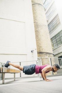 Indian man doing push-ups on bench