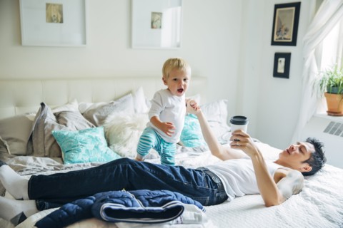 Father and son playing on bed