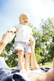 Father and son playing in grass in park