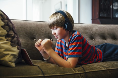 Caucasian boy using digital tablet on sofa