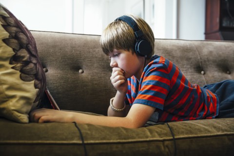 Caucasian boy using digital tablet on sofa