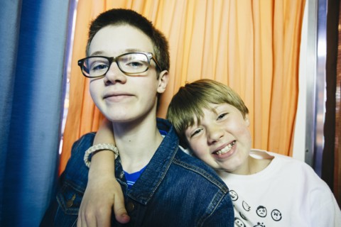 Caucasian brothers smiling in photo booth