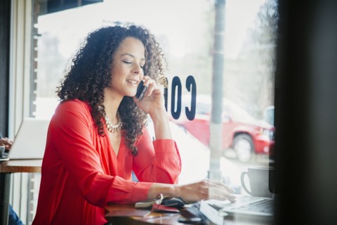 Businesswoman talking on cell phone in cafe