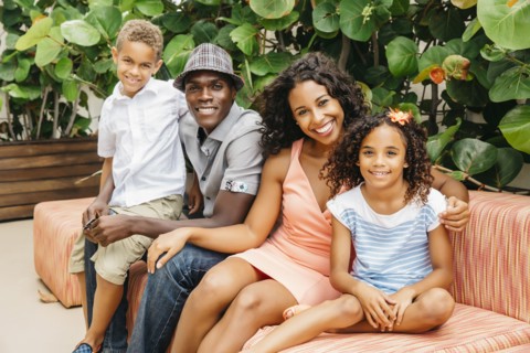 Family smiling on sofa in garden