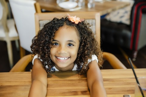 Mixed race girl sitting at restaurant table