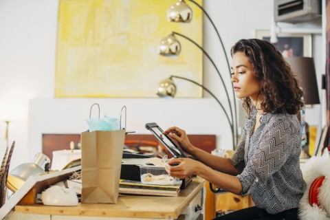 Mixed race clerk using register in shop