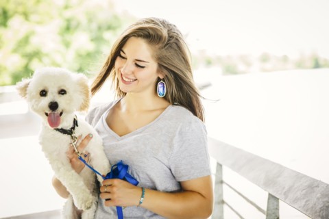 Caucasian woman carrying dog outdoors