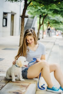 Caucasian woman petting dog on sidewalk