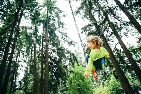 Caucasian girl playing on swing