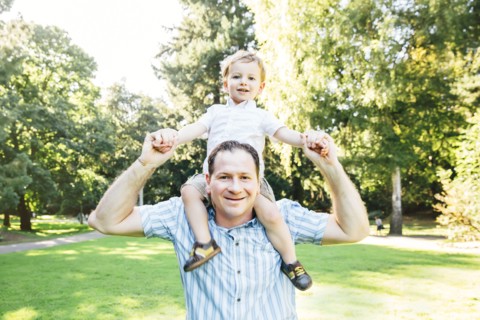 Caucasian father carrying son in park